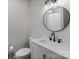 Close up of the vanity featuring a round mirror and updated fixtures at 1601 Mooresville Rd, Salisbury, NC 28147