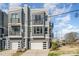 New townhome exterior featuring gray siding, multiple windows, balconies and attached garages on a sunny day at 1659 Duckworth Ave, Charlotte, NC 28208
