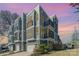 Modern townhome exterior with gray siding, balconies, and attached garages under a vibrant sky at 1659 Duckworth Ave, Charlotte, NC 28208