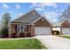 Charming brick home with a well-manicured lawn and a two-car garage and beautiful landscaping at 1668 Onyx Rdg # 116, Fort Mill, SC 29708