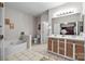 Bright bathroom featuring a soaking tub, double sink vanity, and neutral tile flooring at 1668 Onyx Rdg # 116, Fort Mill, SC 29708