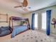 Bedroom features a wooden bunkbed with a blue comforter, a ceiling fan, and two windows with curtains at 18 Pickett Ave, Spencer, NC 28159