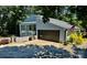 Modern home exterior with a gray facade, dark garage door, and well-manicured landscaping at 18 Pickett Ave, Spencer, NC 28159