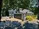 Exterior view of home with large garage, American flag, and manicured landscaping on a sunny day at 18 Pickett Ave, Spencer, NC 28159