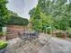 Outdoor patio featuring a cozy seating area surrounded by lush greenery and mature trees at 18 Pickett Ave, Spencer, NC 28159