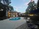 Evening view of backyard pool and patio with outdoor dining set and lounge chairs at 18 Pickett Ave, Spencer, NC 28159
