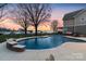 Inviting backyard pool with lake view surrounded by mature trees and a well-manicured lawn at 20601 Island Forest Dr, Cornelius, NC 28031