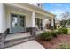 Charming front porch with rocking chairs and stone accents on a light-colored two-story home at 20601 Island Forest Dr, Cornelius, NC 28031