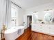 Bright bathroom featuring a soaking tub, wood floors, double vanity, and natural light at 225 Marion St, Rock Hill, SC 29730