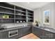A modern pantry with custom gray cabinets, open shelving and light countertops is brightly lit by a window at 2325 Winthrop Ave, Charlotte, NC 28203