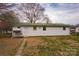 Cozy white home with a green roof, nestled in a spacious backyard with mature trees at 2577 Kingston St, Newton, NC 28658