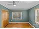 Bedroom with closet, hardwood floors, large windows, and teal walls with white trim at 2913 Archdale Dr, Charlotte, NC 28210