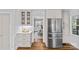 Charming kitchen featuring stainless steel refrigerator, white cabinets, and beautiful hardwood floors at 2913 Archdale Dr, Charlotte, NC 28210