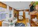 Cozy living room featuring wood paneling, a stone fireplace, and ample natural light at 2913 Archdale Dr, Charlotte, NC 28210