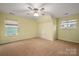 Bright bedroom with ceiling fan, carpeted floors, and natural light from the windows at 3301 Brackhill St, Davidson, NC 28036