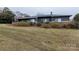Expansive backyard featuring a brick retaining wall and lush green lawn at 404 Downing Dr, Kings Mountain, NC 28086