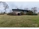 Wide shot of backyard with brick accents and mature trees at 404 Downing Dr, Kings Mountain, NC 28086
