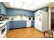 Charming eat-in kitchen featuring blue cabinets, white appliances, and terracotta tile flooring at 404 Downing Dr, Kings Mountain, NC 28086