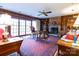 Warm and inviting living room featuring wood paneling, a stone fireplace, and large windows at 404 Downing Dr, Kings Mountain, NC 28086
