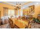 Charming dining area with a long wooden table, chandelier, and stairs to the side at 417 Galesburg Dr, Monroe, NC 28110