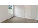 Cozy bedroom with a window and a door features neutral walls and carpet at 419 N Caldwell St # 1, Salisbury, NC 28144