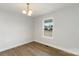Dining area featuring modern light fixture, neutral walls, wood-look floors, and a bright window at 419 N Caldwell St # 1, Salisbury, NC 28144