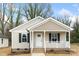 Inviting home featuring a gabled roof, neutral siding, black shutters, and a cozy front porch with white railings at 419 N Caldwell St # 1, Salisbury, NC 28144