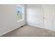 Bedroom featuring neutral carpet, light walls, a bright window, and a white door at 423 N Caldwell St # 2, Salisbury, NC 28144