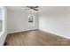 Bright, neutral bedroom featuring wood-look floors, a ceiling fan, and a large window for natural light at 423 N Caldwell St # 2, Salisbury, NC 28144