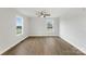 Spacious bedroom with wood-look floors, neutral tones, a ceiling fan, and two windows at 423 N Caldwell St # 2, Salisbury, NC 28144