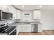 Well-lit kitchen with stainless appliances, granite countertops, stainless sink, and white cabinets at 423 N Caldwell St # 2, Salisbury, NC 28144