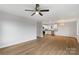 Open-concept living room features light-wood flooring, white walls, and a ceiling fan adjacent to the kitchen at 423 N Caldwell St # 2, Salisbury, NC 28144