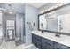 Bathroom with double vanity, shower with curtain, and large mirror with vanity lighting at 4405 Ashton Ct, Indian Trail, NC 28079