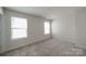 Carpeted bedroom with neutral walls and two windows at 50 Sherwood Nw Ct # Sw50, Concord, NC 28027