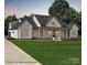 Inviting new construction farmhouse with white siding, a dark roof, and a covered porch at 5104 Lowie Ln # 23, Gastonia, NC 28056