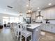 Bright kitchen with white cabinets, stainless steel appliances, a large island with seating, and modern pendant lighting at 527 Morrows Turnout Way, Pineville, NC 28134