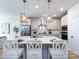 Open-concept kitchen with a large island, white countertops, pendant lighting, stainless steel appliances, and barstool seating at 527 Morrows Turnout Way, Pineville, NC 28134