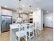 Open concept kitchen featuring a large island with bar seating, white cabinets, stainless appliances, and access to dining at 527 Morrows Turnout Way, Pineville, NC 28134