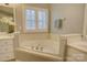 Bathroom showcasing a large soaking tub with window and white shutter, and sink with white vanity at 5306 Club View Dr, Concord, NC 28025