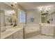 Bright bathroom includes soaking tub, double sinks with white vanities, and decorative lighting at 5306 Club View Dr, Concord, NC 28025
