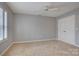 Neutral bedroom features a ceiling fan, plush carpet, bright windows, and a closet with double doors at 5306 Club View Dr, Concord, NC 28025