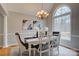 Formal dining room featuring elegant chandelier, large window, and seating for six, perfect for hosting gatherings at 5306 Club View Dr, Concord, NC 28025