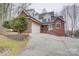 View of traditional two-story home with brick facade, attached garage, and well-manicured landscaping at 5306 Club View Dr, Concord, NC 28025