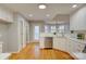 Well-lit kitchen with white cabinetry, stainless steel dishwasher, and hardwood flooring at 5306 Club View Dr, Concord, NC 28025