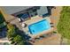 Aerial view of the pool and backyard area, with seating, a manicured lawn and mature trees at 5608 Old Town Ln, Gastonia, NC 28056