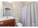 Cozy bathroom with a single vanity, wood cabinet, toilet, and shower with curtain at 5608 Old Town Ln, Gastonia, NC 28056