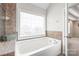 Relaxing bathtub area with a large window for natural light, tile accents, and plush rolled towels at 5608 Old Town Ln, Gastonia, NC 28056