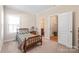Bright bedroom with a traditional bed frame, plush carpet, and a door to the bathroom at 5608 Old Town Ln, Gastonia, NC 28056