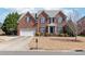 Charming brick home with a well-manicured lawn, mature trees, and a spacious driveway in a peaceful neighborhood at 5608 Old Town Ln, Gastonia, NC 28056