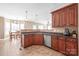 Well-lit kitchen area with stainless steel dishwasher, dark granite counter, sink, and tile flooring at 5608 Old Town Ln, Gastonia, NC 28056